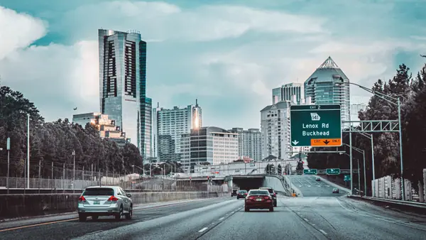 Scenic view of Buckhead skyline in Atlanta, Georgia. Cars on expressway under cloudy sky.