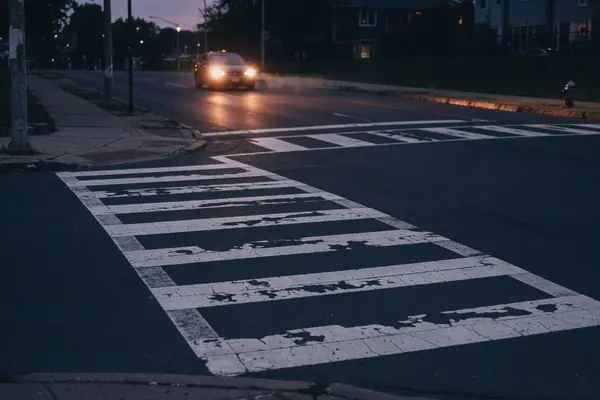 Illustration: a marked crosswalk at dusk.